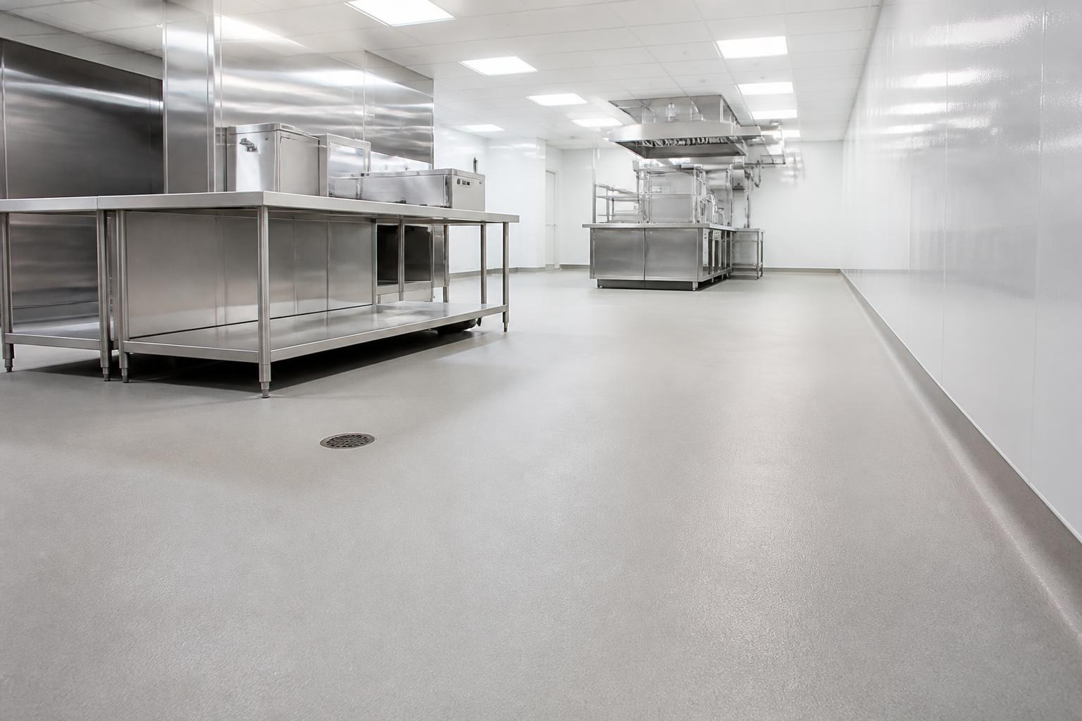 Seamless resinous floor with coved base in a stainless steel commercial kitchen